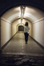 Woman walking through an underground tunnel Royalty Free Stock Photo