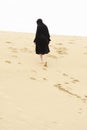 Woman walking up sand hill Royalty Free Stock Photo