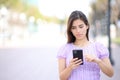 Woman walking using cell phone in the street