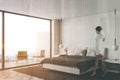 Woman walking in white bedroom corner with balcony Royalty Free Stock Photo