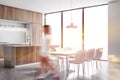 Woman walking in white and wood kitchen, table Royalty Free Stock Photo