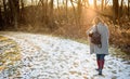 Woman walking in the woods in winter at sunset Royalty Free Stock Photo