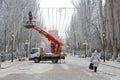 A woman walks along the Alley of Heroes and worker on the crane install Illuminated ceiling with led garlands in Volgograd