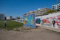 A woman walks along East Side Gallery, Berlin Wallin in front of modern buildings, Berlin, Germany Royalty Free Stock Photo