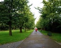 A woman walks along a path in Bute Park, Cardiff , Wales Royalty Free Stock Photo