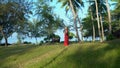 The woman walks with a backpack. High palm trees on the island.Phu of Quoc Island. the woman in a red dress with a