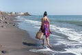 Woman walks on the beach with shopping Royalty Free Stock Photo