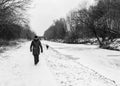 A woman walks down the frozen canal towpath