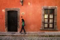 Woman walks in front of traditional colonial houses in San Miguel de Allende