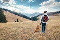 Woman walks with her beagle dog on autumn mountain hill