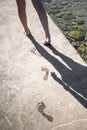 Woman walks and leaves wet footprint.