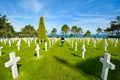 A woman walks through the Normandy American Cemetery and Memorial at Colleville-sur-Mer with rows of gravestones. Royalty Free Stock Photo