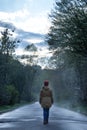 Woman walks at the park in rainy foggy day