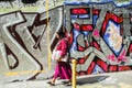 Woman walks past graffiti wall in Belleville, Paris, France. Royalty Free Stock Photo