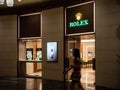 A woman walks past a Rolex luxury watch boutique in Singapore, Southeast Asia