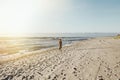 Woman walks on sunset beach, vintage style.