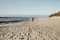 Woman walks on sunset beach, vintage style.