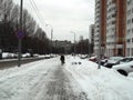 A woman walks on a winter road in the city