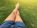 Woman ware short jean sitting on the green grass