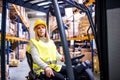 Woman warehouse worker with forklift.