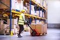 Woman warehouse worker with hand forklift truck. Royalty Free Stock Photo