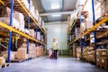 Woman warehouse worker with hand forklift truck. Royalty Free Stock Photo