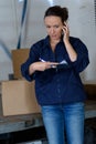 Woman warehouse worker with smartphone Royalty Free Stock Photo