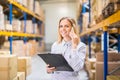 Woman warehouse worker or supervisor with smartphone. Royalty Free Stock Photo