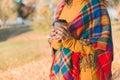 Woman in warm colorful plaid holding paper cup of coffee Royalty Free Stock Photo