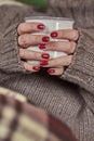 A woman holds a mug with a hot drink in her hands. Royalty Free Stock Photo