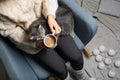 Woman in warm sweater with cute cat sitting in armchair