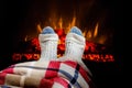 Woman warming feet in woolen socks near fireplace Royalty Free Stock Photo