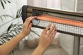 Woman warming hands near electric infrared heater indoors, closeup Royalty Free Stock Photo