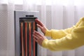 Woman warming hands near heater indoors, closeup Royalty Free Stock Photo