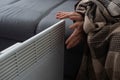 Woman warming hands near heater indoors, closeup Royalty Free Stock Photo