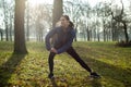 Woman Warming Up For Morning Exercise With Stretches In Winter Park