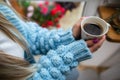 A woman warms her frozen hands against a mug of hot coffee. Royalty Free Stock Photo