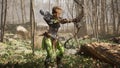 A woman warrior with a bow and arrow prepares to meet the enemy in the sunny forest. Historical medieval concept. 3D