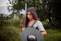 A woman warrior with combat makeup in a chainmail top with plate shoulder pads and bracers poses in a combat Royalty Free Stock Photo