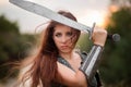 A woman warrior with combat makeup in a chainmail top with plate shoulder pads and bracers poses in a combat Royalty Free Stock Photo