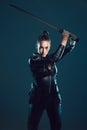 Woman, warrior and vigilante in cosplay with sword ready for battle, war or game against a dark studio background Royalty Free Stock Photo