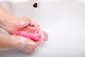 Woman wash soapy hands in bathroom