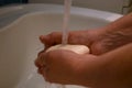 A woman washes her hands with soap under a tap with water. Prevention and control of the outbreak of Wuhan coronavirus infection