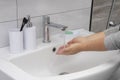 A woman washes her hands under a stream of water. Modern bathroom interior Royalty Free Stock Photo