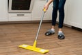 A woman washes underfloor heating in her house. A mop in the hands of a housekeeper