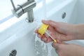 Woman washing baby bottle nipple under stream of water, closeup Royalty Free Stock Photo