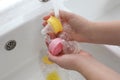 Woman washing baby bottle nipples under stream of water, above view