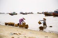 Woman washing baskets for anchovies used for fish sauce on February 7, 2012 in Mui Ne, Vietnam. Royalty Free Stock Photo