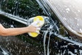 Woman washing black car with sponge on her house Royalty Free Stock Photo