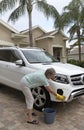 Woman washing the bodywork of a white saloon car Royalty Free Stock Photo